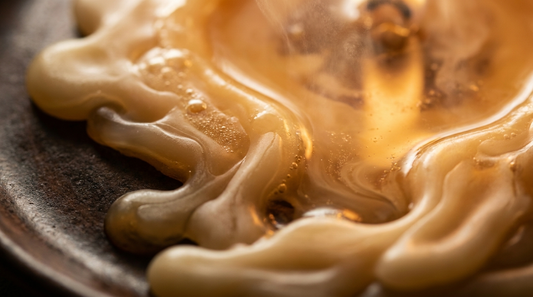 Wax melt e tart profumate: cera di soia che si scioglie lentamente, texture dorata in primo piano